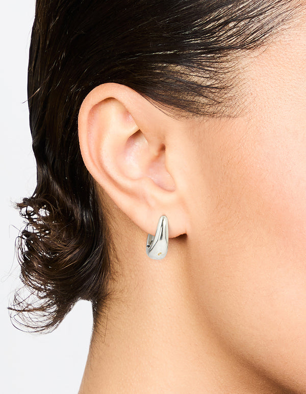 Showcasing waterproof mini drop huggie earrings crafted from stainless steel on ear view