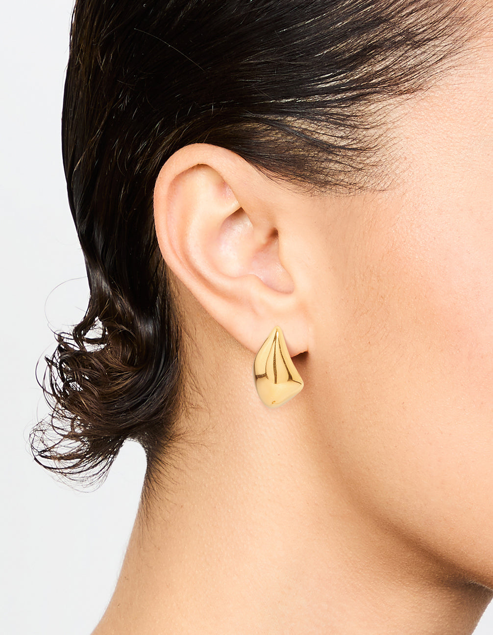 Showcasing waterproof stainless steel organic drop earrings in gold plated finish on ear view