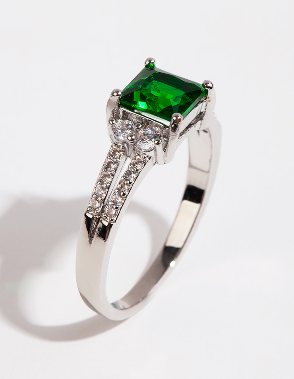 Showcasing a silver square emerald cubic zirconia ring with green stone and split band front view