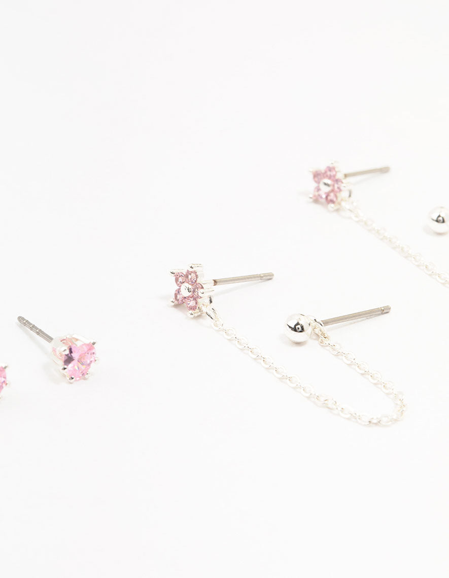 Crafted from silver plated brass, these heart flower chain earrings in a 3-pack showcase floral charm details with pink accents close up view