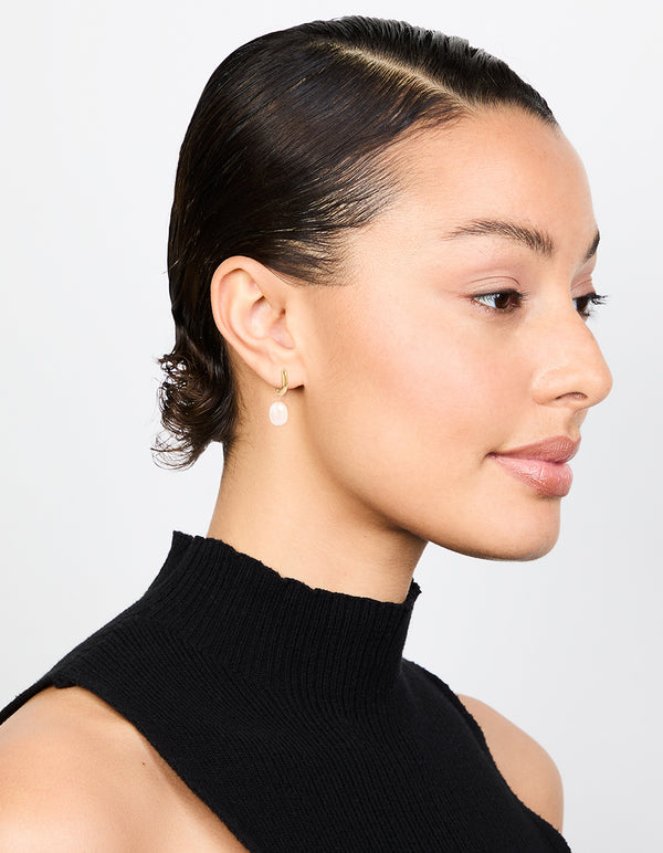 Featuring waterproof gold plated stainless steel freshwater pearl drop huggie earrings in white on model view