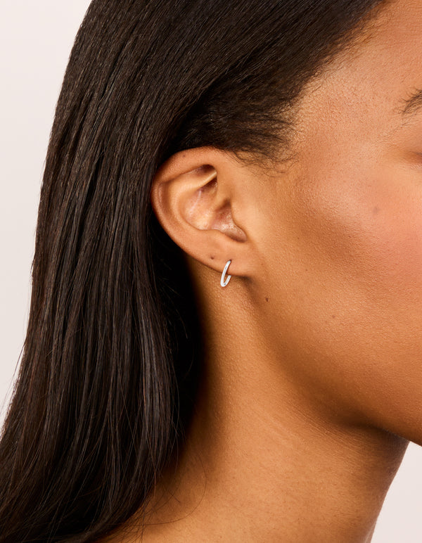 Showcasing waterproof stainless steel sleeper earrings in 10 MM silver on ear view
