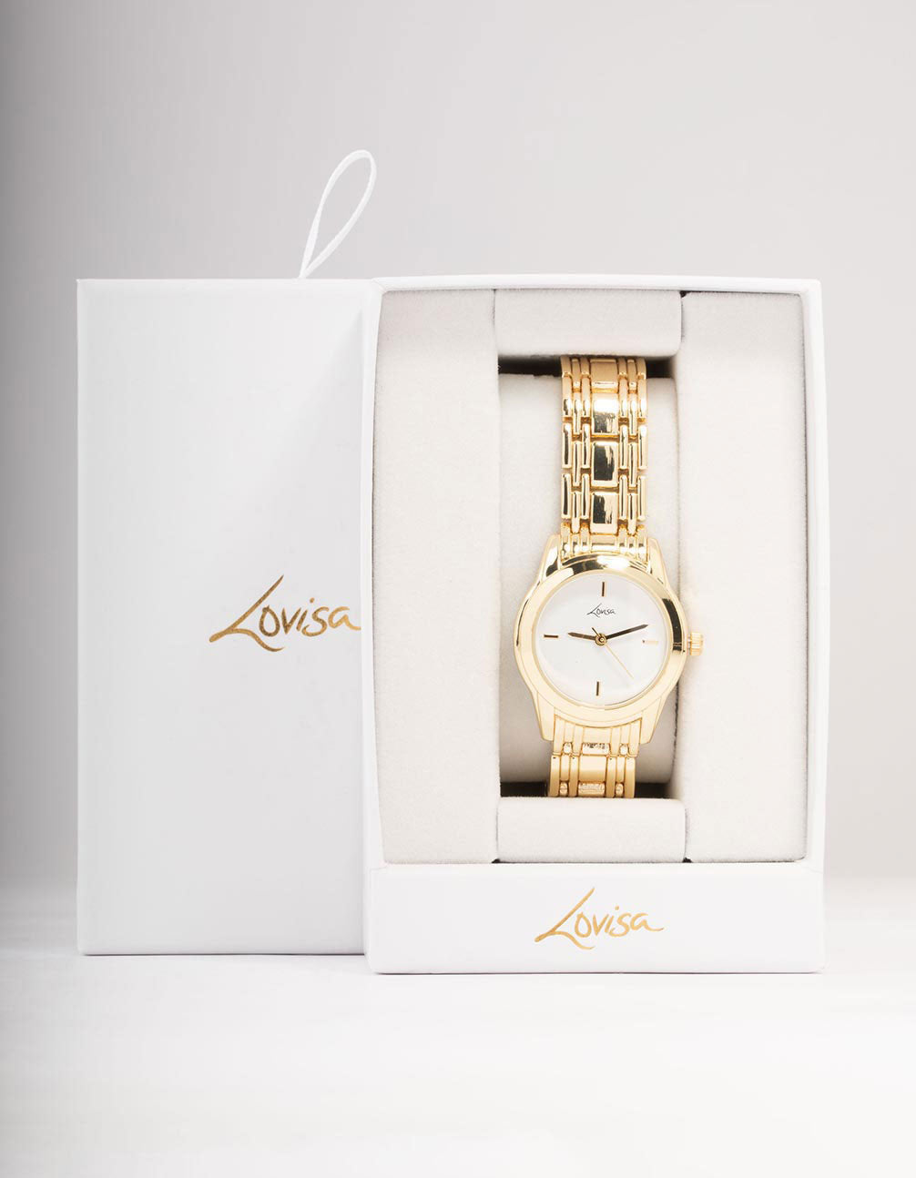 Displayed in packaging, this women's analog watch with white dial, round shape, formal occasion styling, link band strap in gold, displayed in packaging case detail view