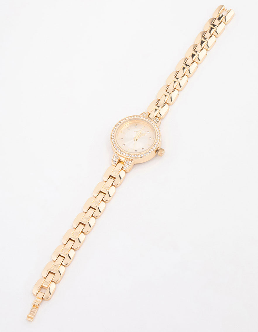 Sophisticated small diamante timepiece featuring white stone-adorned dial, round shape, formal occasion design, link-band strap in gold, and analog mechanics front view