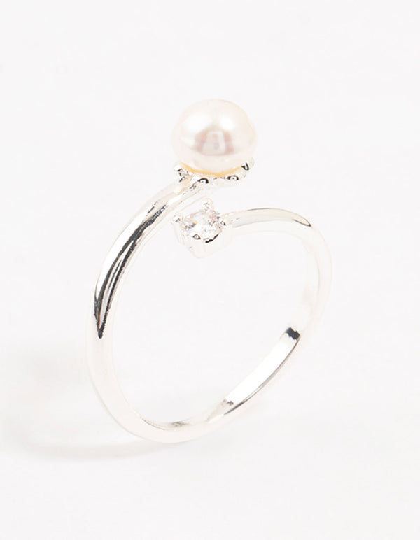 Showcasing a dainty silver plated ring wrapped with cubic zirconia and pearl accents side detail view