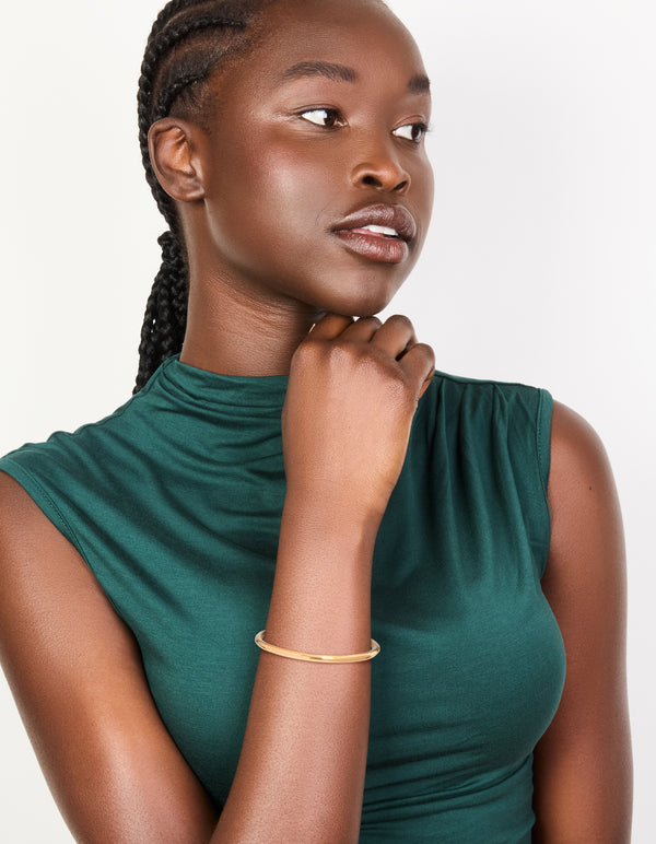 Featuring waterproof gold plated stainless steel, this simple hinge bracelet is displayed on model view