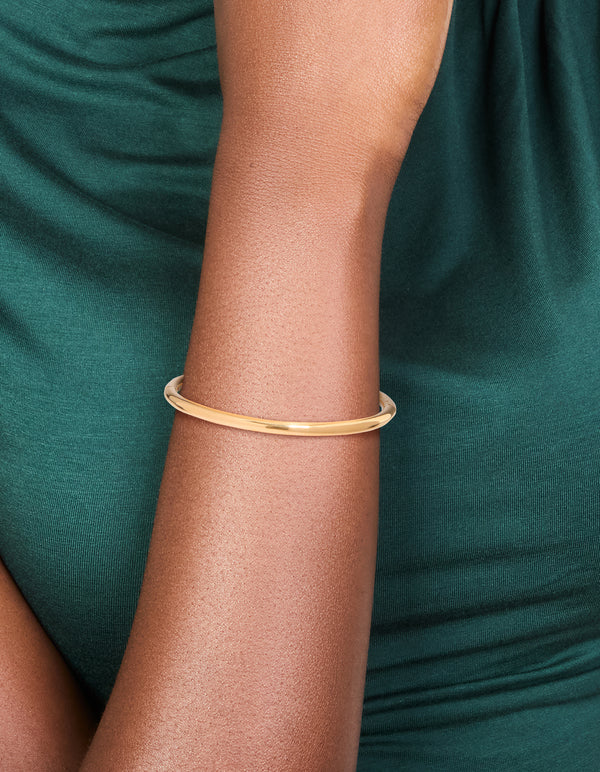Crafted from waterproof gold plated stainless steel, this simple hinge bracelet is shown on wrist view
