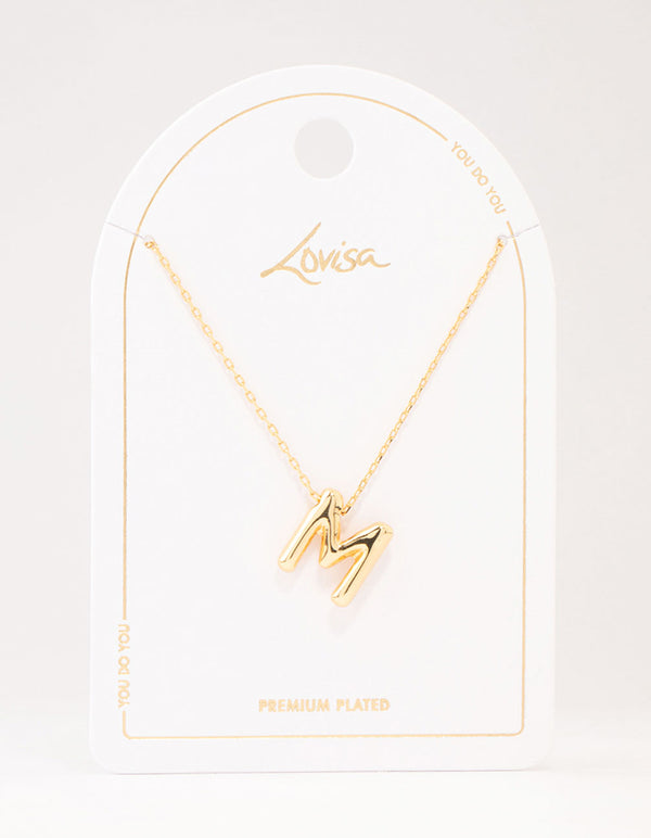 Showcasing a bubble letter M necklace with initials in gold plated finish close up view