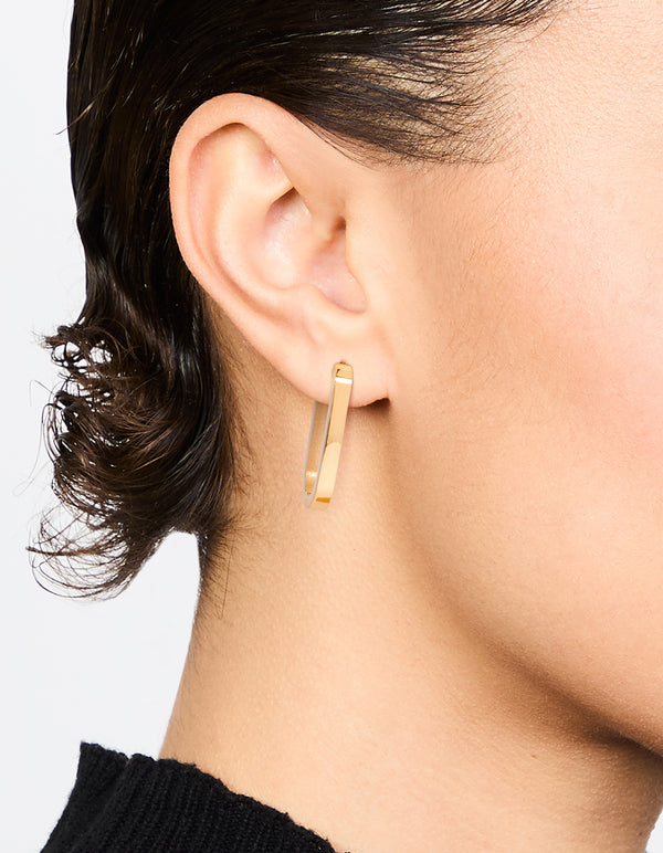 Showcasing waterproof gold plated stainless steel oblong hoop earrings in gold on ear view