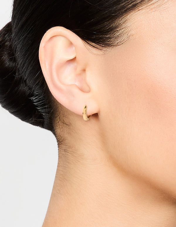 Featuring waterproof gold plated stainless steel thin clicker earrings worn comfortably on ear view