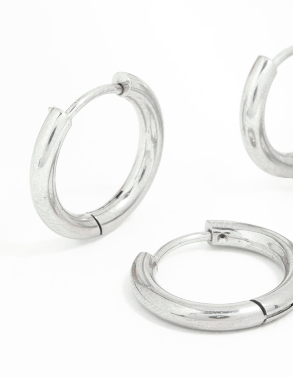 Showcasing surgical steel thick hoop earrings in a 2-pack with silver closure close up view