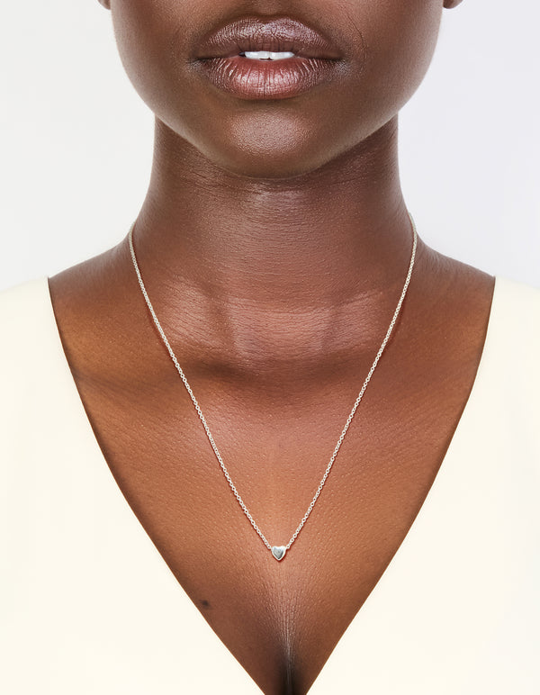 Featuring a heart pendant in sterling silver, this necklace is shown on neck view