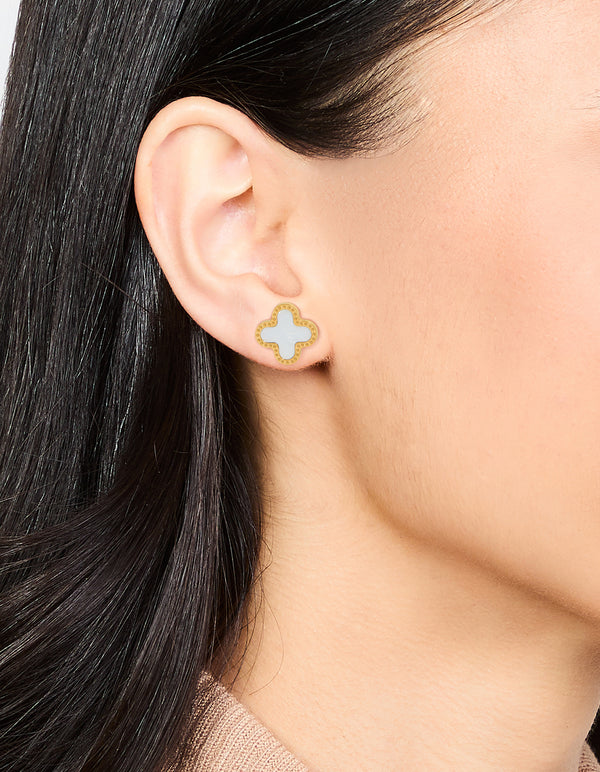 Featuring waterproof stainless steel stud earrings with floral enamel design in gold plated finish on ear view