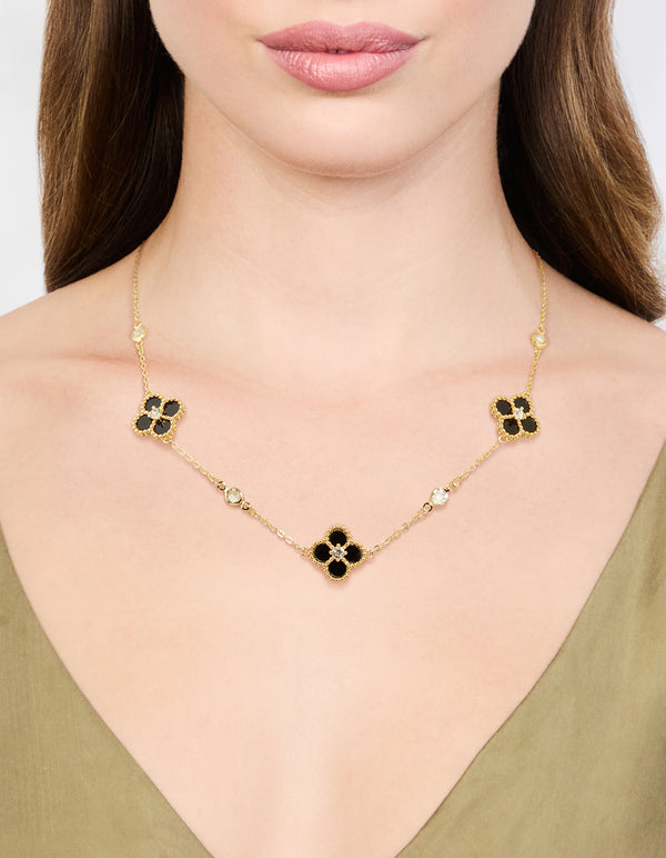 Showcasing gold plated cubic zirconia black flower pendant necklace with floral and crystal details on neck view