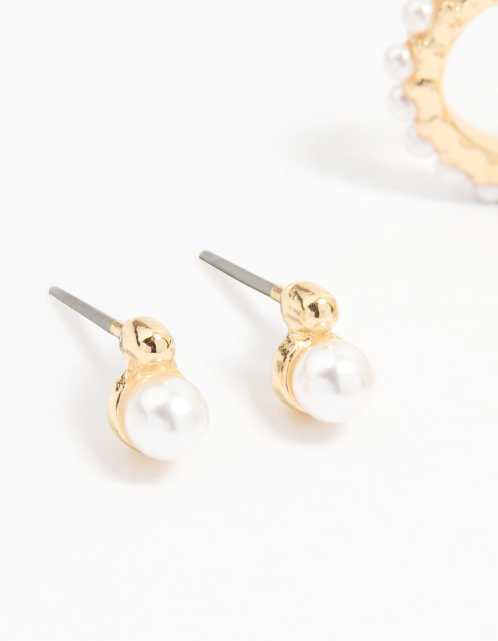 Crafted from gold with mixed pearl huggie earrings in a 3-pack close up view