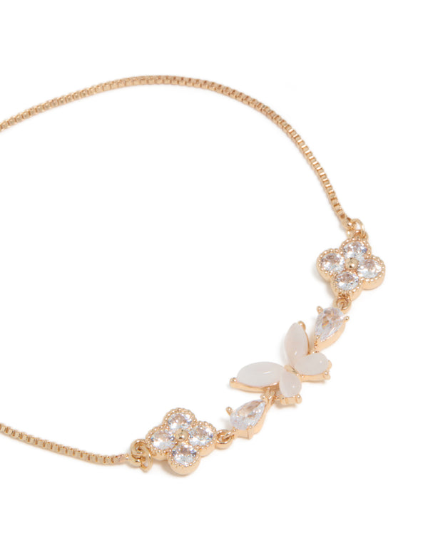 Detailed view of gold cubic zirconia butterfly and flower toggle bracelet in white with close up view