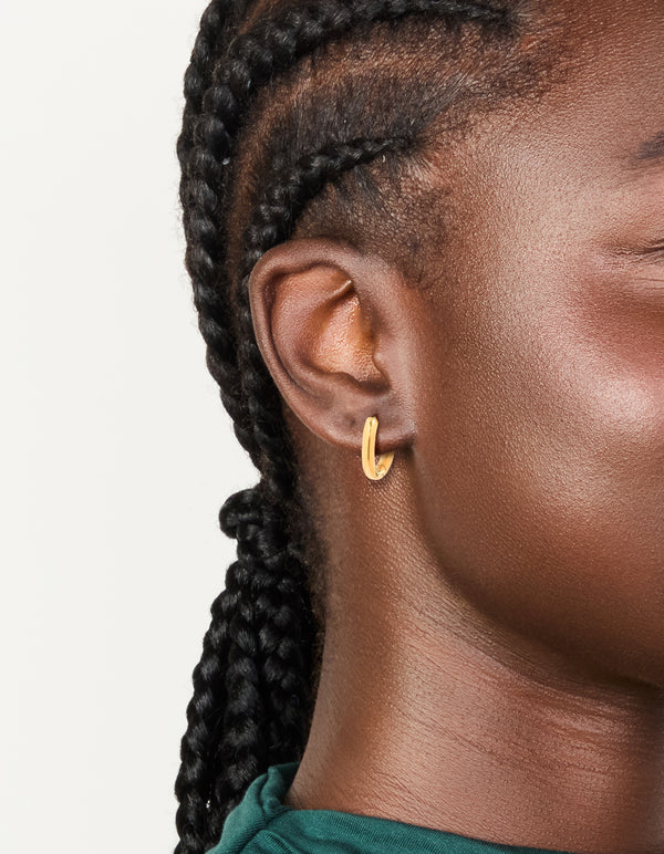 Showcasing waterproof gold plated stainless steel oval clicker hoop earrings on ear view