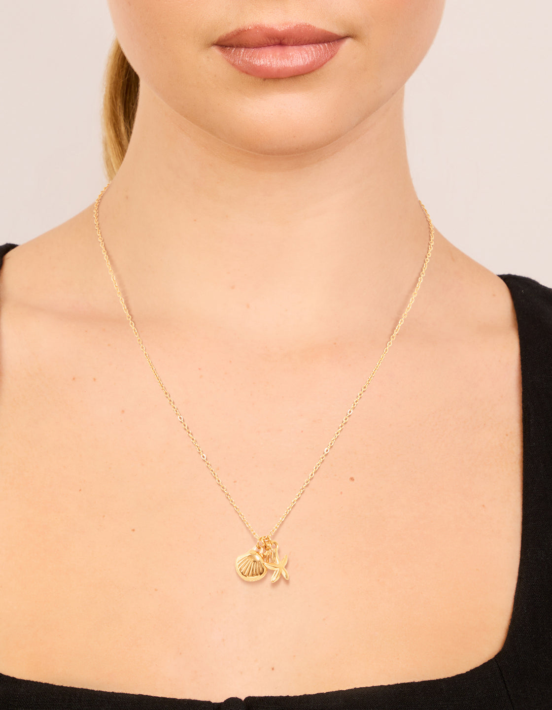 Featuring ocean charm pendant with shell crafted from waterproof gold plated stainless steel in dainty necklace on neck view