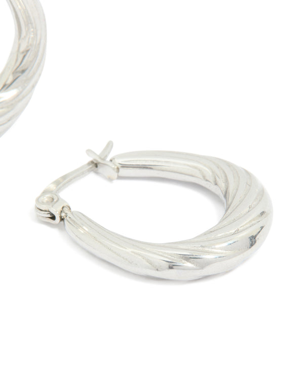 Showcasing waterproof textured stainless steel oval hoop earrings in silver post detail view