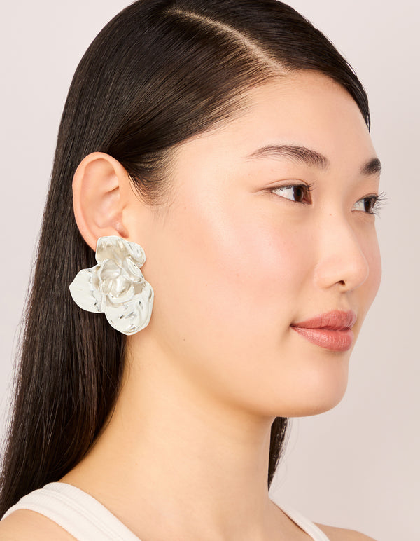 Designed with waterproof stainless steel, statement flower stud earrings featuring floral in silver on model view