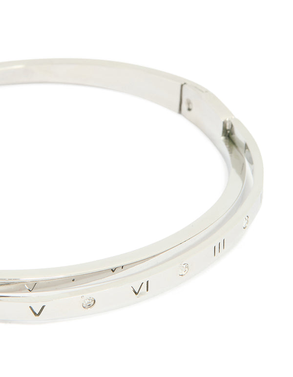 Highlighting a waterproof stainless steel diamante Roman numeral hinge bangle in silver with engraved numbers and statement appeal close up view
