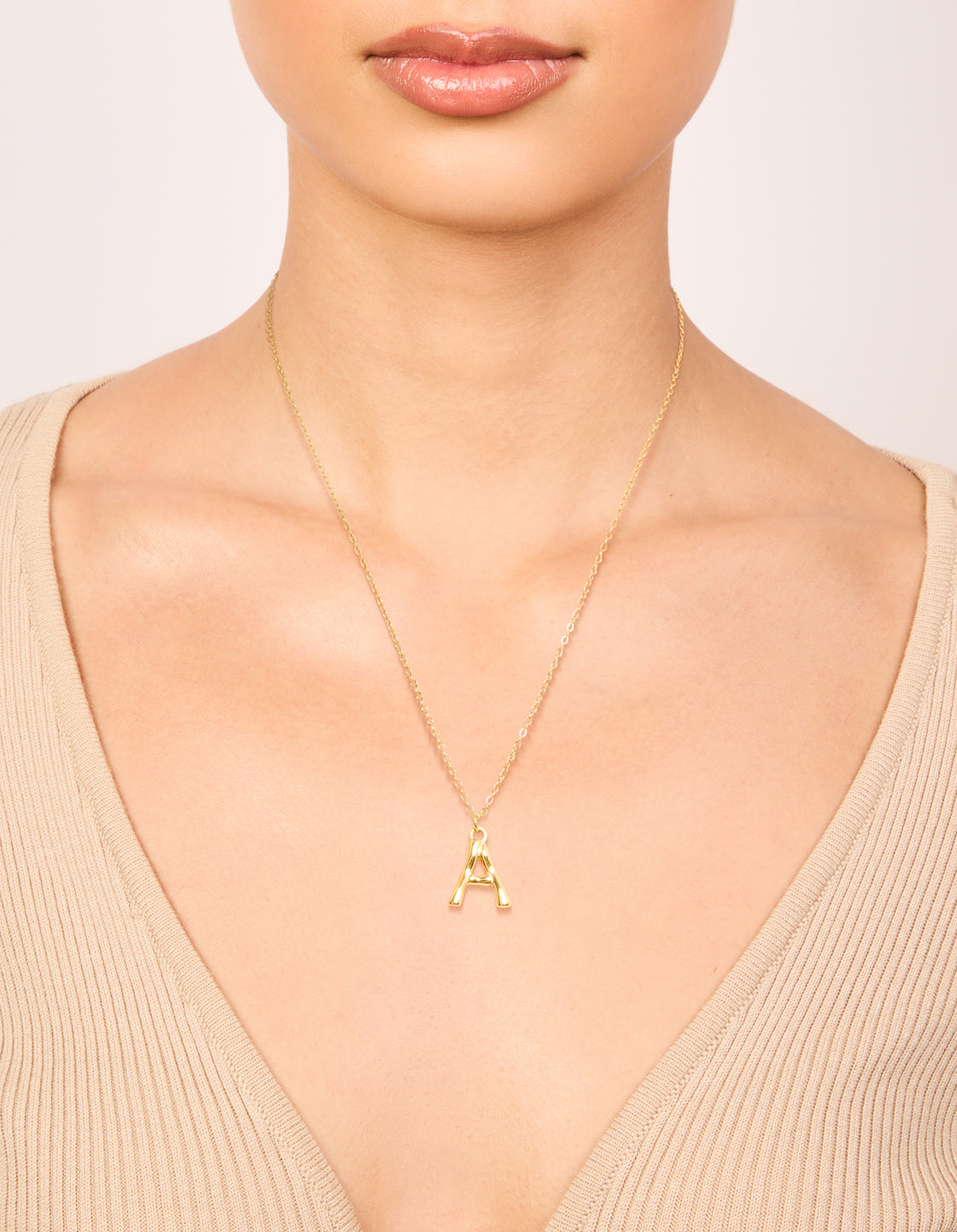 Discover a waterproof gold-plated stainless steel bamboo letter A initial necklace with a pendant on neck view