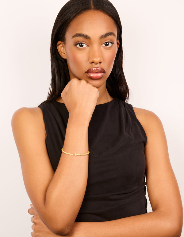 Presenting a waterproof gold plated stainless steel cubic zirconia ball tennis stretch bracelet featuring beaded details on model view