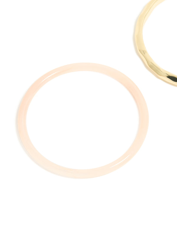 Crafted from gold plated material with pink acrylic, this statement bangle 2-pack close up view