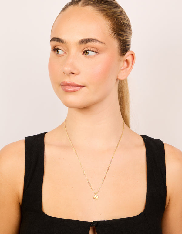 Featuring a waterproof bubble letter H necklace crafted from gold plated stainless steel with initial pendant on model view