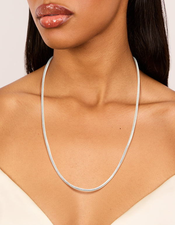 Showcasing a waterproof stainless steel short snake chain necklace in silver on neck view