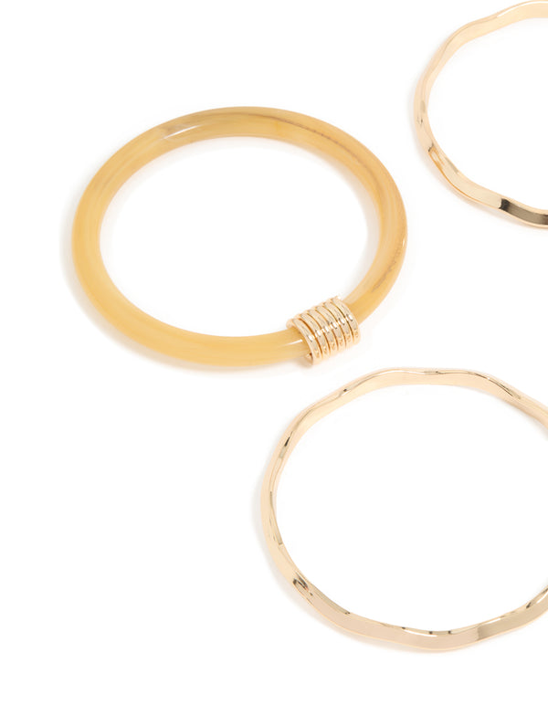 Showcasing neutral acrylic and gold wavy bangles in a 4-pack close up view