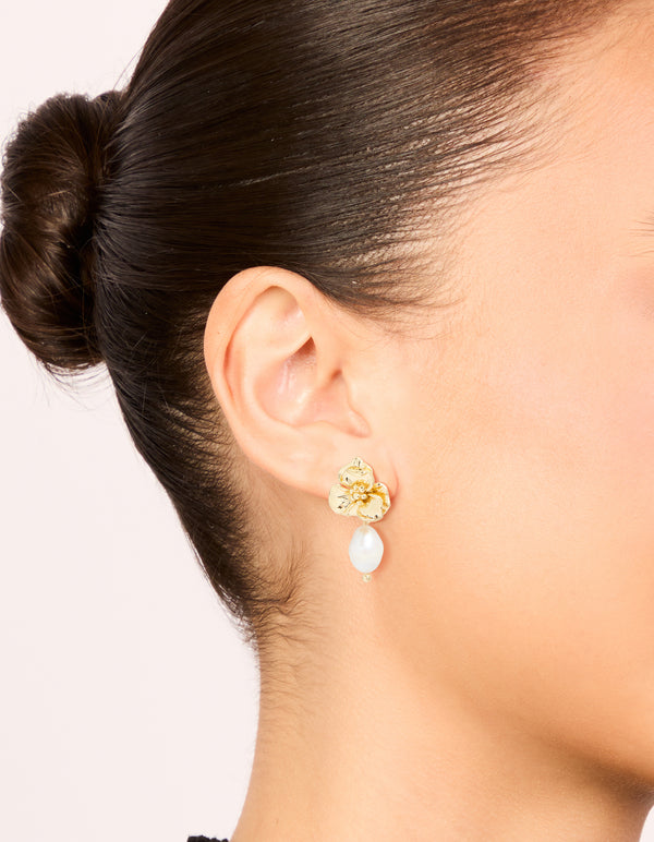 Stunning gold plated freshwater pearl flower drop earrings featuring floral charm design with statement ivory accents on ear view