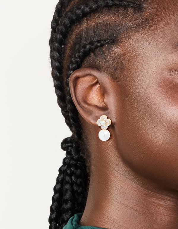 Elegant gold plated cubic zirconia flower and pearl drop earrings in clear and ivory on ear view
