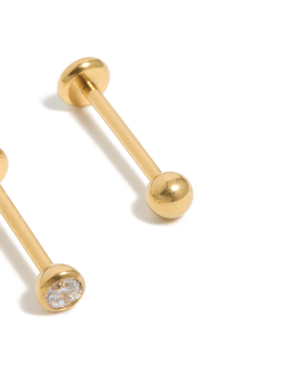 Highlighting gold-plated titanium bezel threadless flat back nose studs crafted with ball accents and diamond embellishments close up view