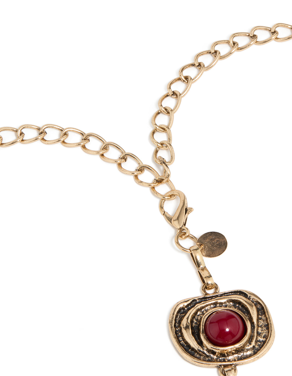 Showcasing an antique gold organic circle belt featuring dark red stones and an embellished pattern in a bold statement style detail view