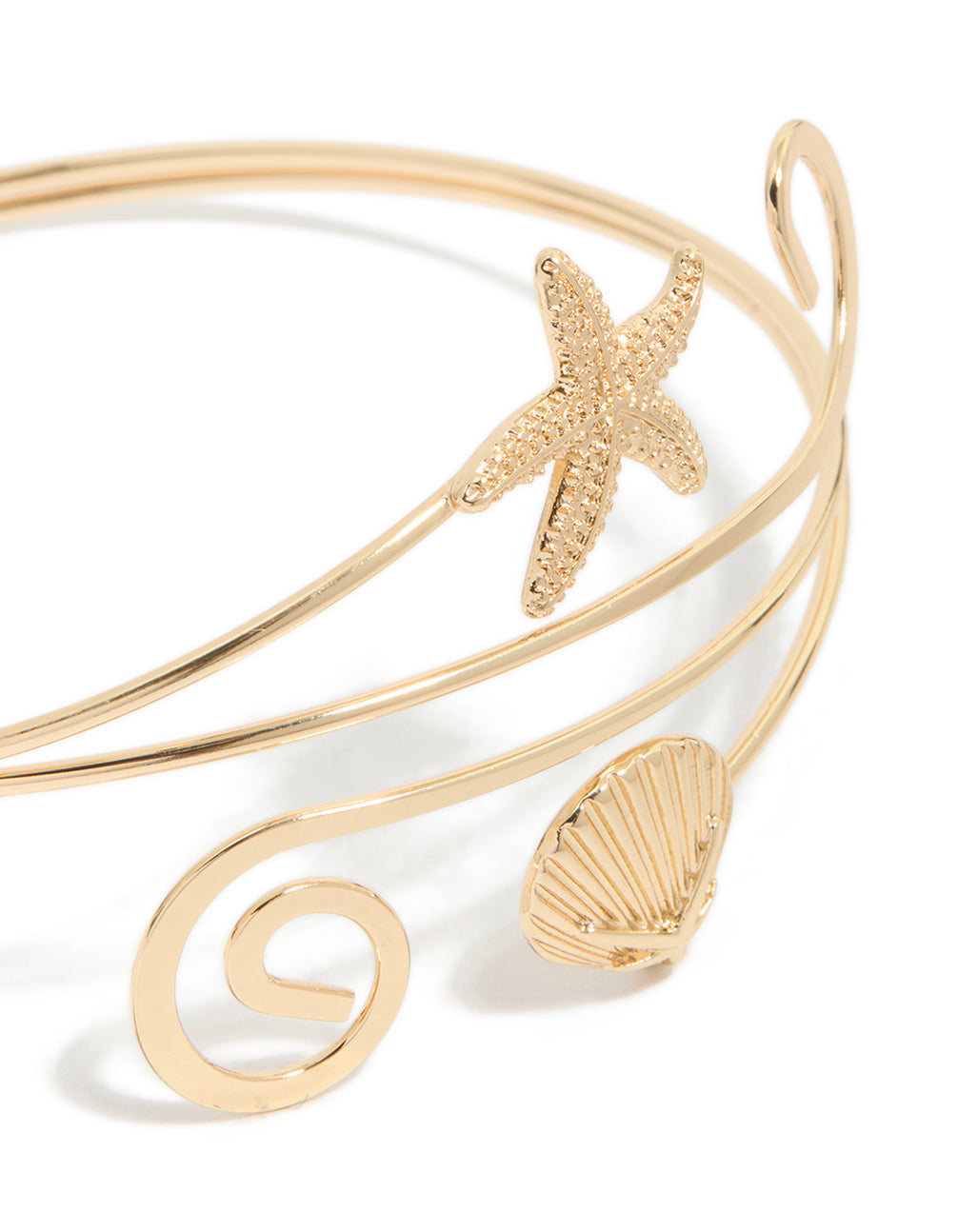 Crafted from gold, this starfish and shell arm cuff features animal and ocean-inspired details in close up view