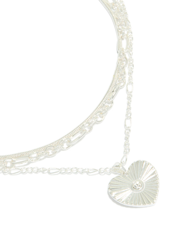 Showcasing a silver plated chain and diamante heart layered necklace close up view