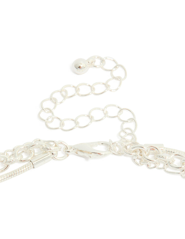Highlighting a silver plated chain and diamante heart layered necklace clasp detail view
