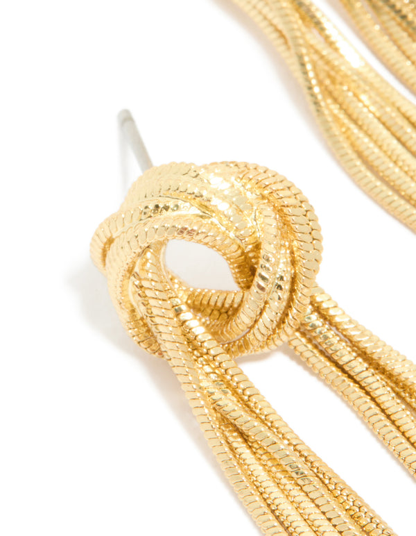 Designed with a knot stud, these gold plated statement fringe earrings close up view