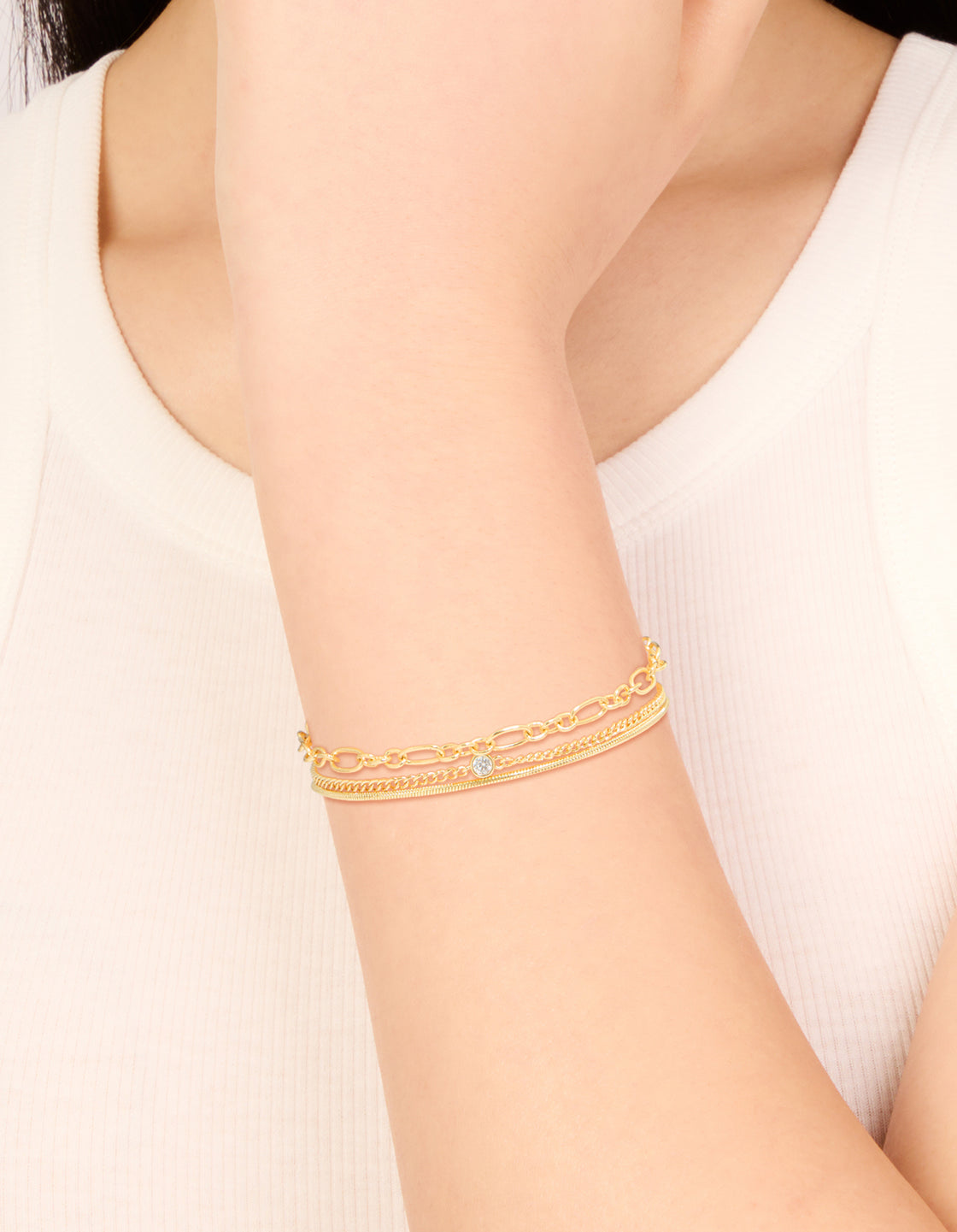 Showcasing gold plated cubic zirconia and chain bracelets in a 3-pack on wrist view