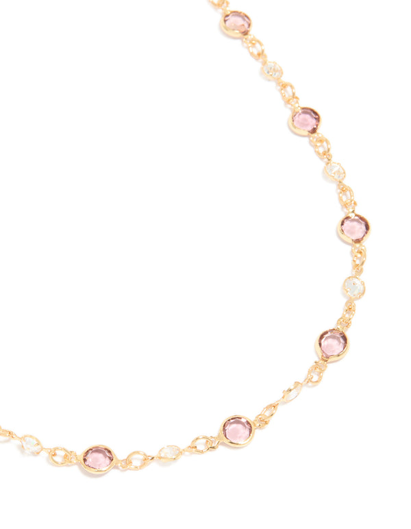 Featuring a gold plated station necklace with pink and clear cubic zirconia stones in round cut close up view