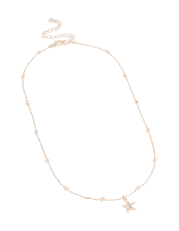 Elegantly designed rose gold starfish pendant necklace with balls and ocean theme front view