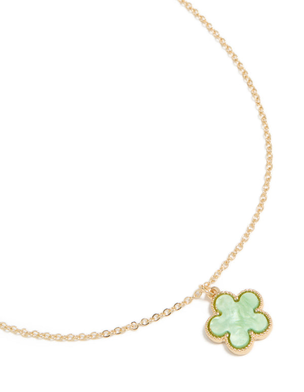 Showcasing a gold necklace with light green 5 petal flower pendant close up view