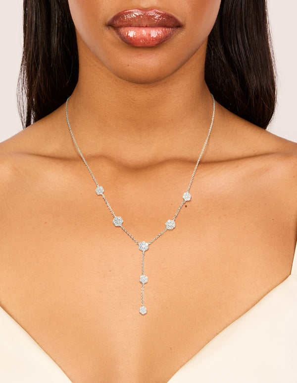 Showcasing a cubic zirconia mini floral y necklace in dainty silver on neck view