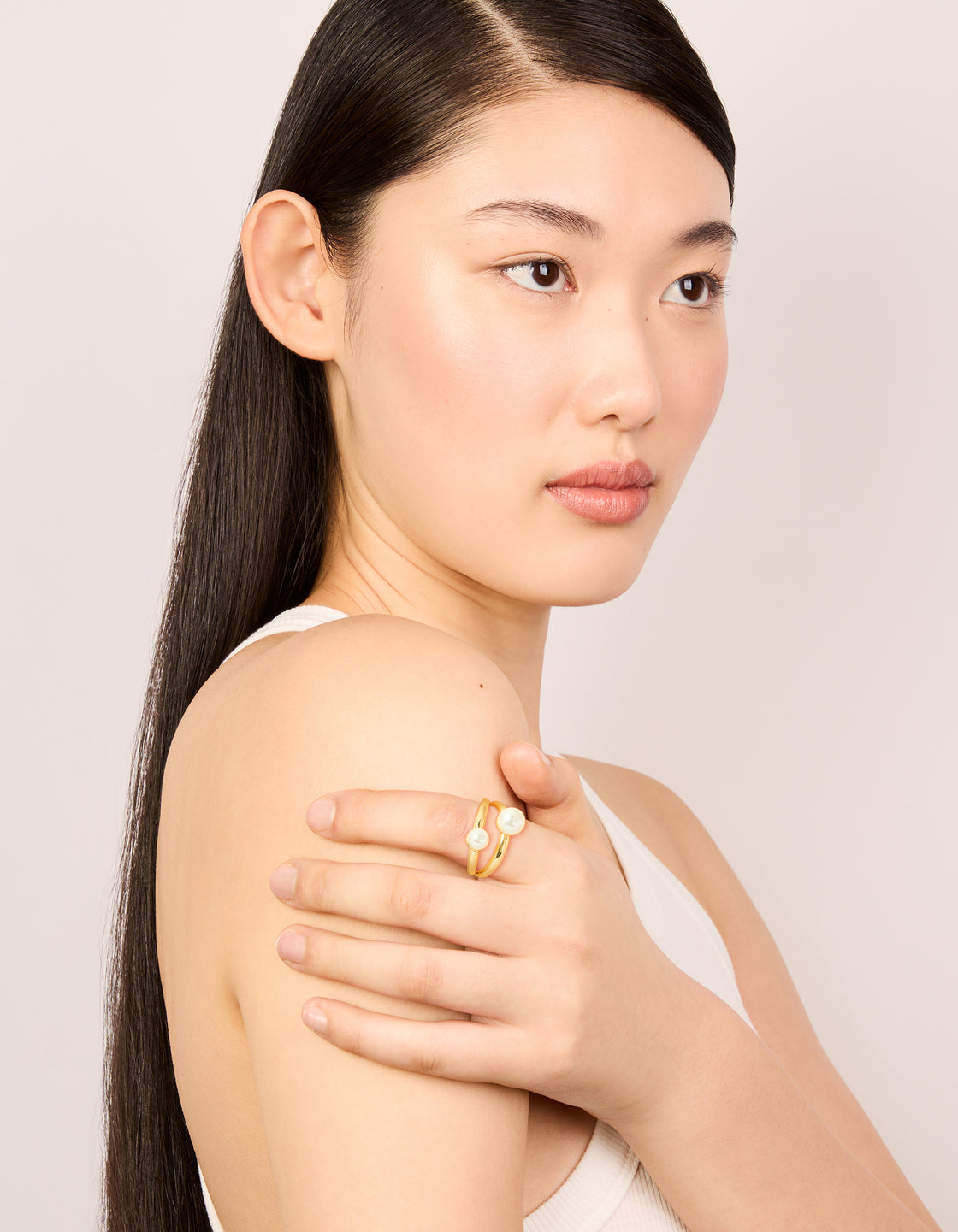 Showcasing a waterproof gold plated stainless steel pearls split band ring on finger view