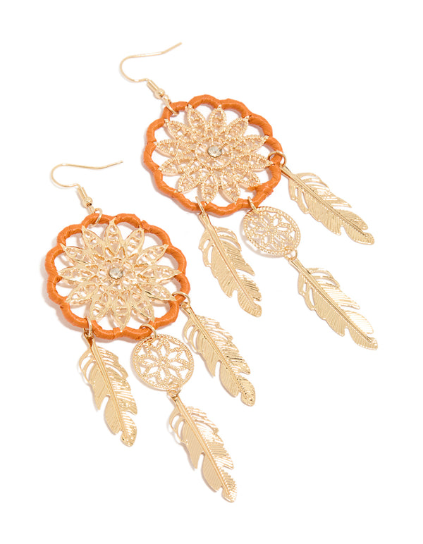Beautifully crafted statement drop earrings featuring dreamcatcher design with charm, feathers, and orange yarn detailing in gold front view
