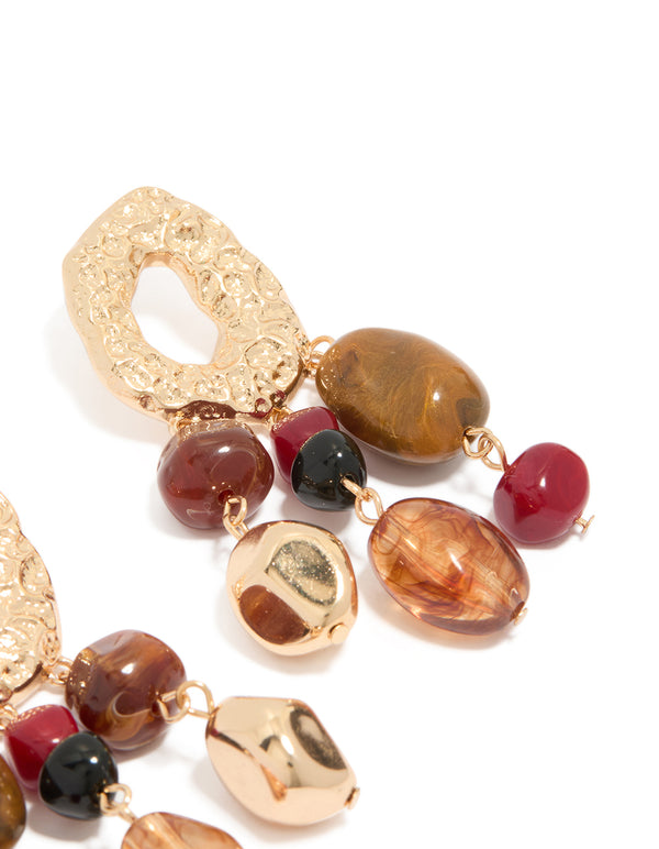 Elegant irregular beaded drop earrings with charm elements and statement aesthetic highlighting textured detailing post detail view