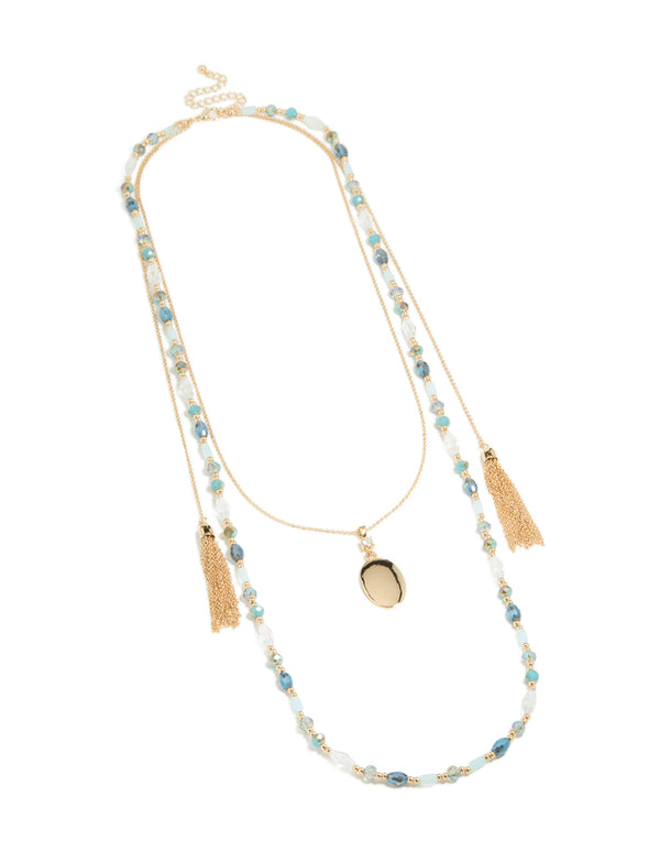 Featuring this layered necklace with blue beads, tassel and oval pendant in statement styling in gold front view