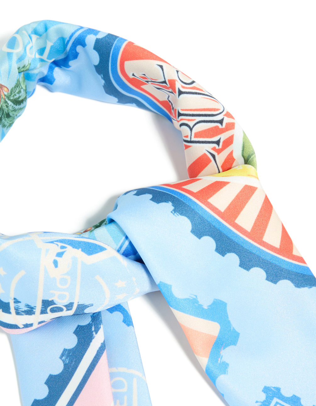 Showcasing the Blue Fabric Paradise Vacation Print Scarf in light blue, yellow, and green detail view