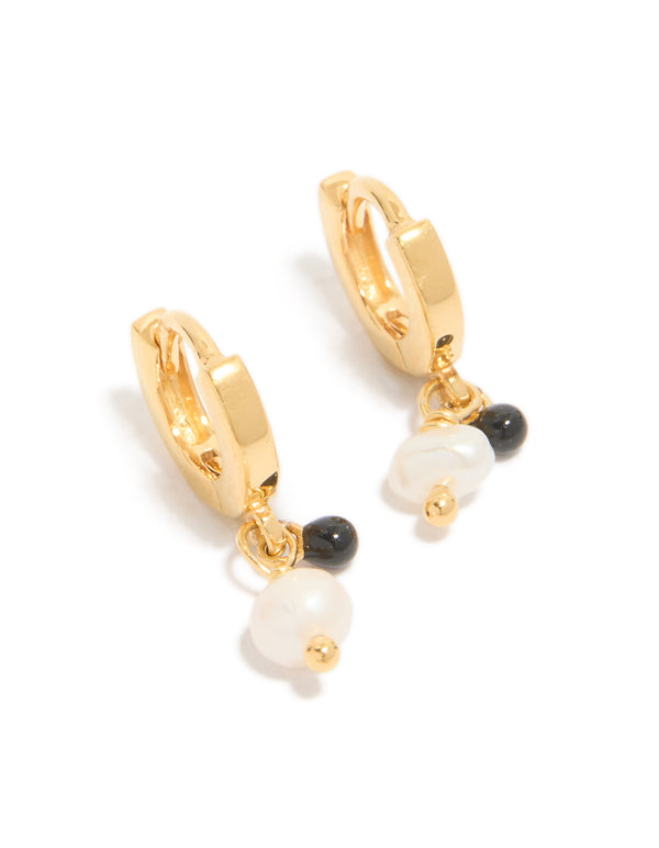 Showcasing gold plated sterling silver and pearl drop huggie earrings with huggie closure in ivory and black front view